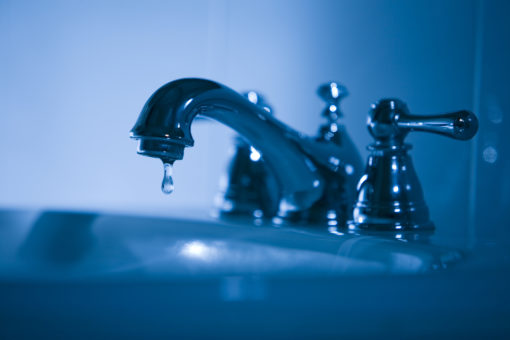 A faucet with water gently dripping from the spout