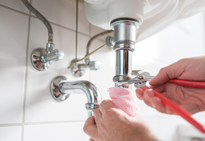 An individual is adjusting a sink faucet